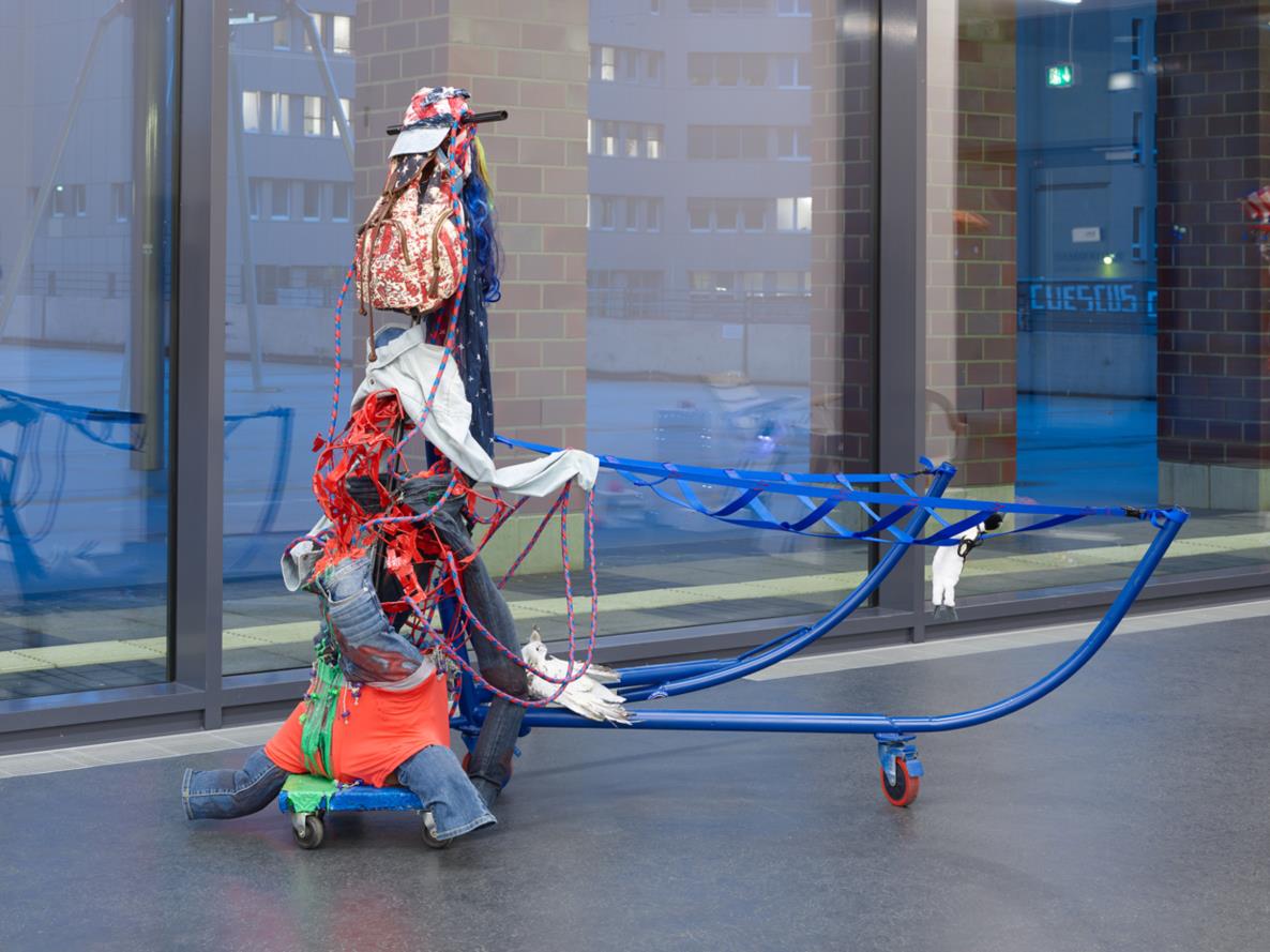 LIZZIE FITCH/RYAN TRECARTIN: Game Ampersand, 2015, gaming chair, plaster strips, bond, epoxy, spray paint, safety pins, steel casters, plastic, pillow, paper towel racks, plastic bone, hair clips, tire dog toy and bell, dog poop collection bag dispenser, decorative burlap wraps, dog leash, model landscaping foam moss, craft store gravel, cut garden boats, panty hose, panty hose socks, foam, plastic, wire, dog bone biscuits, dog bone circles, zip ties, 'Burbank' sun hat, cork tape, hair extension, decorative sea sponge, decorative burlap flowers, safety pins, hemp ropes, craft string, swimming goggles, rubber bracelet, ribbon, straw, plastic palm tree, flower pot holder, wrist brace, hand brace, hernia brace pad, chicken wire, plastic cactus, gaffer's tape, rope, fake antler, ampersand 182 x 171 x 118 cm